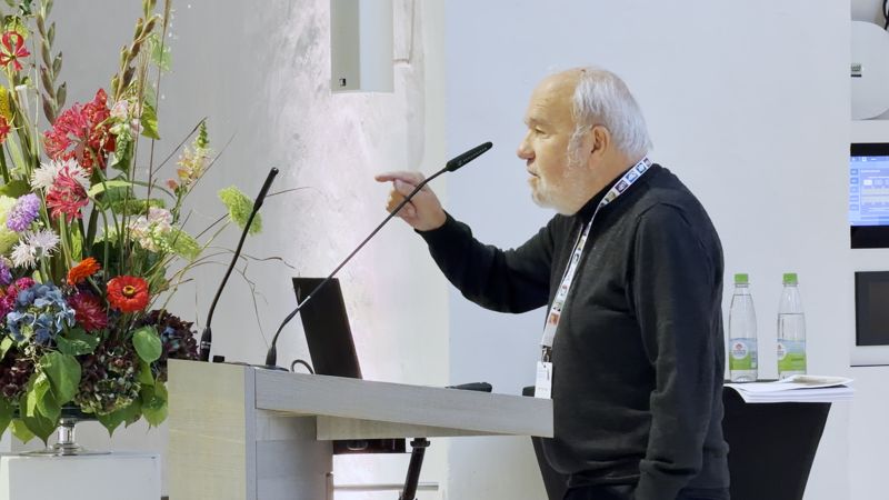 Festvortrag am Rednerpult mit Blumenschmuck in der Dominikaner-Aula