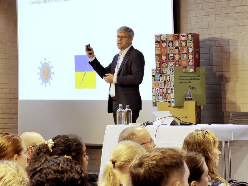 Vortrag am Samstag vor vollem Saal, daneben der AVM-Aufsteller