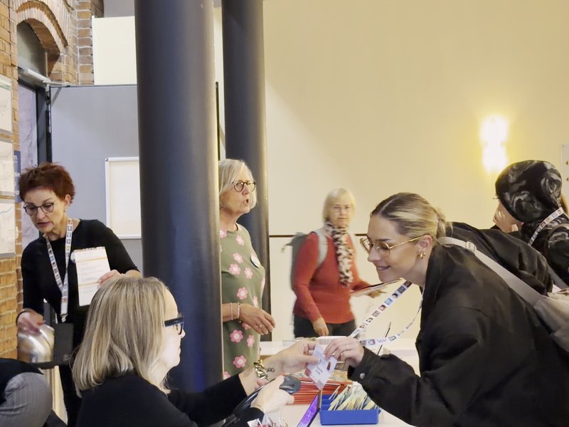 Teilnehmende erhalten ihre Namensschilder am Anmeldetisch im Welcome Kongress Hotel